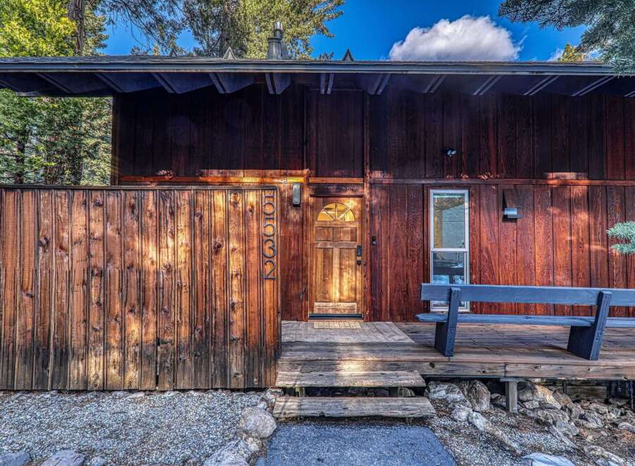 This stunning property boasts a rustic charm with its wooden exterior and inviting entrance.