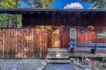 This stunning property boasts a rustic charm with its wooden exterior and inviting entrance.