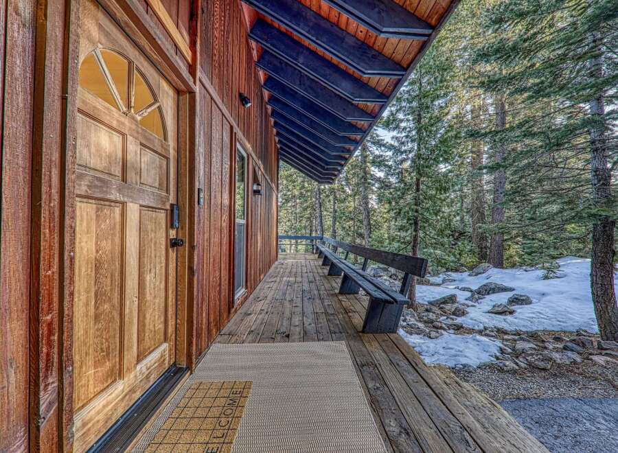 Welcome to your mountain retreat! This charming home features a beautiful wooden door and a welcoming porch, perfect for enjoying the serene surroundings.