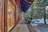 Welcome to your mountain retreat! This charming home features a beautiful wooden door and a welcoming porch, perfect for enjoying the serene surroundings.