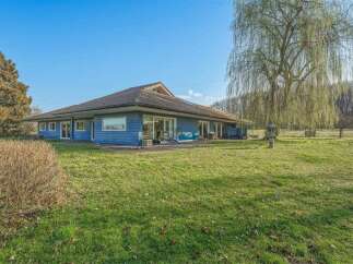 This stunning property boasts a beautiful blue exterior and a spacious, well-maintained lawn, perfect for outdoor activities.