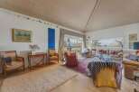 Step into this inviting living space, featuring a vaulted wooden ceiling and abundant natural light.