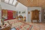 Step into this inviting entryway, featuring a striking red door and natural light pouring in from the skylights.