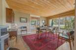 Step into this inviting dining room, featuring a beautiful wooden ceiling and a striking red rug that adds warmth and character.