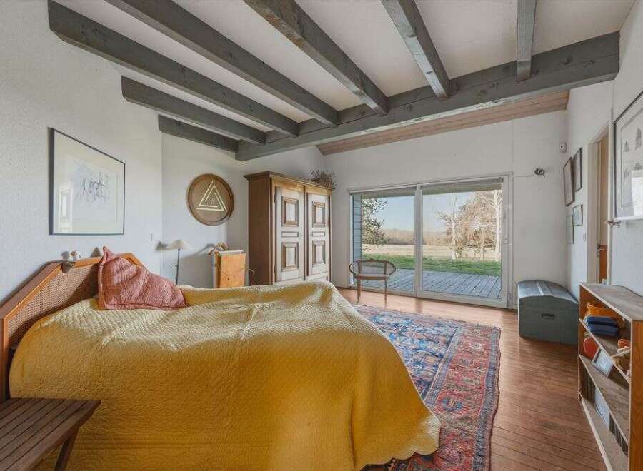 This charming bedroom boasts a rustic aesthetic with exposed wooden beams and a cozy atmosphere.