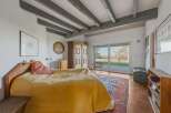 This charming bedroom boasts a rustic aesthetic with exposed wooden beams and a cozy atmosphere.