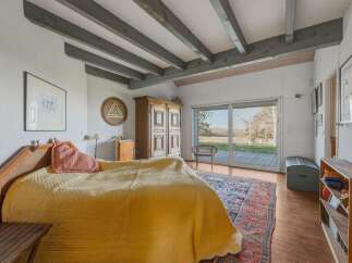 This charming bedroom boasts a rustic aesthetic with exposed wooden beams and a cozy atmosphere.