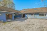 This stunning property boasts a charming blue exterior and a spacious gravel driveway, perfect for multiple vehicles.