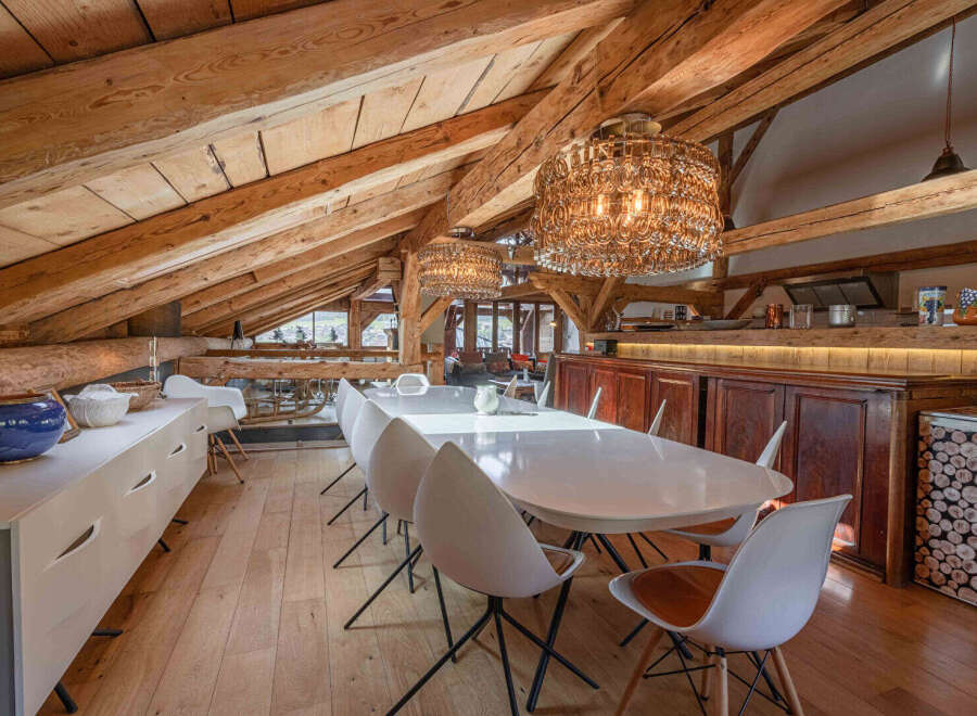 Experience the charm of this stunning property, featuring a unique dining area with exposed wooden beams and elegant lighting.