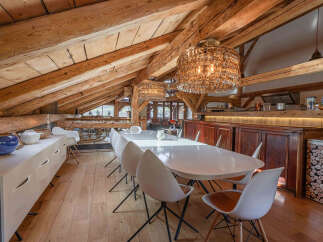 Experience the charm of this stunning property, featuring a unique dining area with exposed wooden beams and elegant lighting.