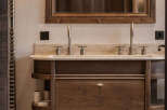 This stunning bathroom boasts a luxurious wooden vanity with ample storage and a sleek marble countertop.