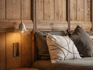 This cozy bedroom features a stunning wooden headboard, creating a warm and inviting atmosphere.