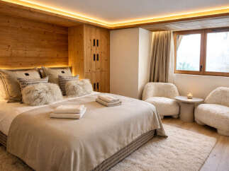 Experience luxury in this stunning bedroom featuring a cozy bed with plush pillows and a warm, inviting ambiance.