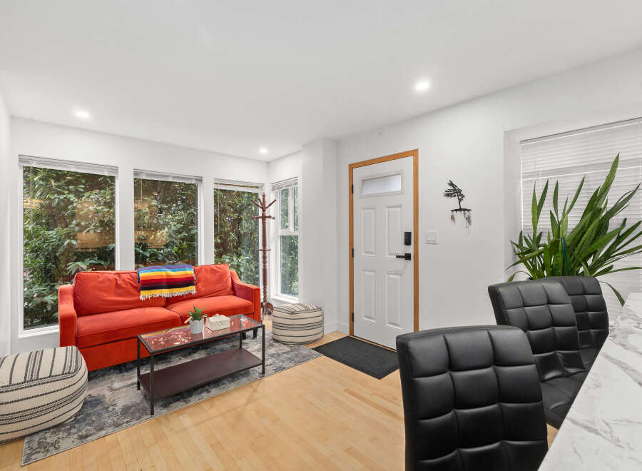 Step into modern living with this stylish property, featuring a vibrant red sofa and a cozy rug.