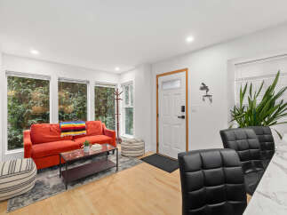 Step into modern living with this stylish property, featuring a vibrant red sofa and a cozy rug.