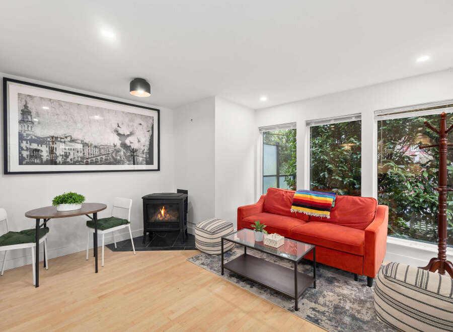 This cozy living space features a vibrant red sofa, perfect for relaxing.