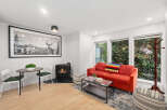 This cozy living space features a vibrant red sofa, perfect for relaxing.