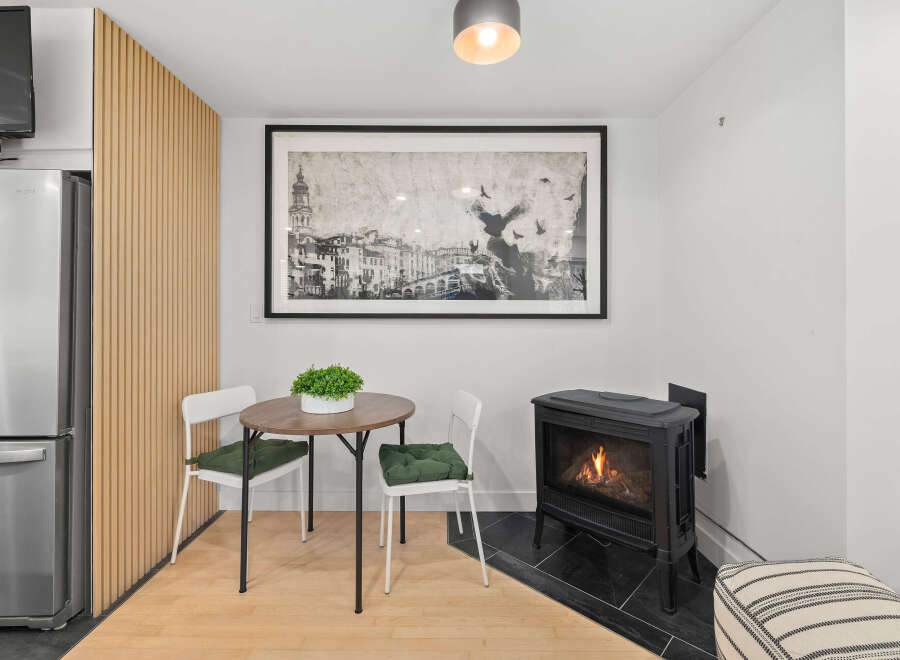 This cozy space features a charming dining area with a round table and two chairs, perfect for intimate meals.