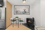 This cozy space features a charming dining area with a round table and two chairs, perfect for intimate meals.