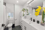 This stunning bathroom boasts a modern design with sleek white cabinetry and a spacious vanity.