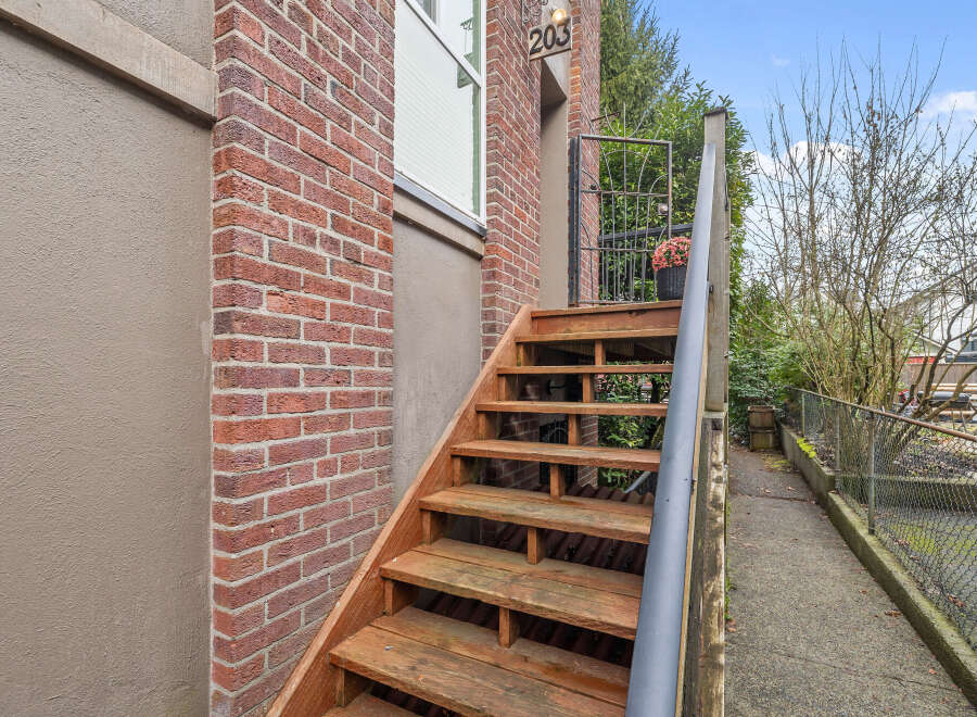 Discover this charming property featuring a welcoming exterior with a brick facade and wooden staircase.