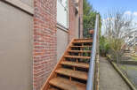 Discover this charming property featuring a welcoming exterior with a brick facade and wooden staircase.