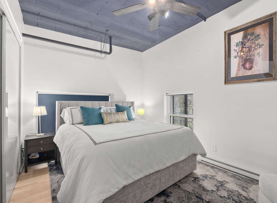 This stunning bedroom boasts a unique design with a striking blue ceiling and a cozy, inviting atmosphere.