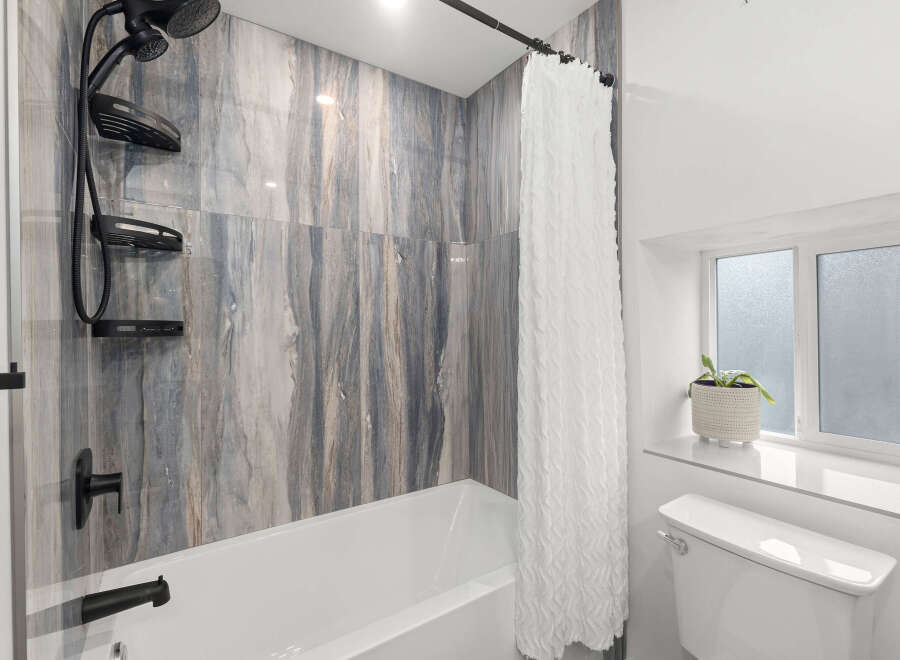 Step into a beautifully designed bathroom featuring stunning marble-look tile.