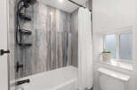 Step into a beautifully designed bathroom featuring stunning marble-look tile.