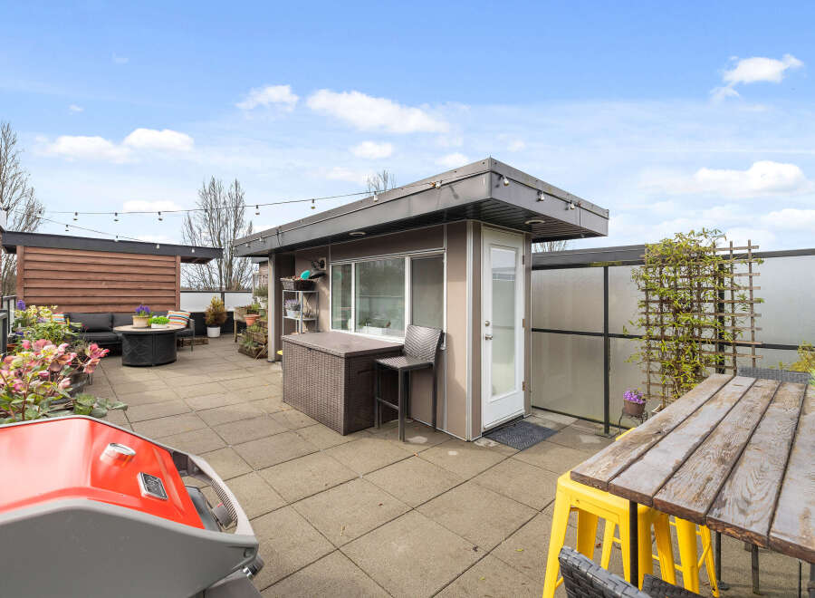 Enjoy outdoor living at its finest with this stunning rooftop patio! This space features a modern outdoor kitchen, a cozy seating area, and a dining table perfect for entertaining.