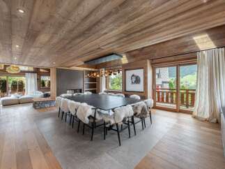 Experience luxury living in this stunning property featuring a spacious dining area with a large table and cozy fur-covered chairs.