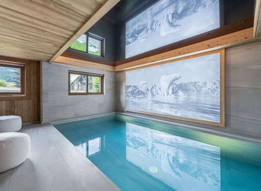 Indulge in luxury with this stunning indoor pool, featuring a captivating polar bear mural and a sleek, modern design.