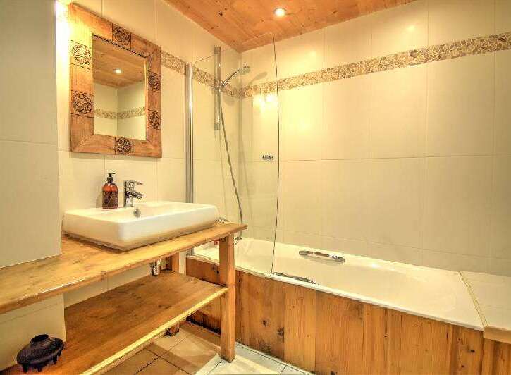 Discover the charm of this bathroom, featuring a rustic wooden vanity and a sleek, modern sink.