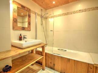 Discover the charm of this bathroom, featuring a rustic wooden vanity and a sleek, modern sink.