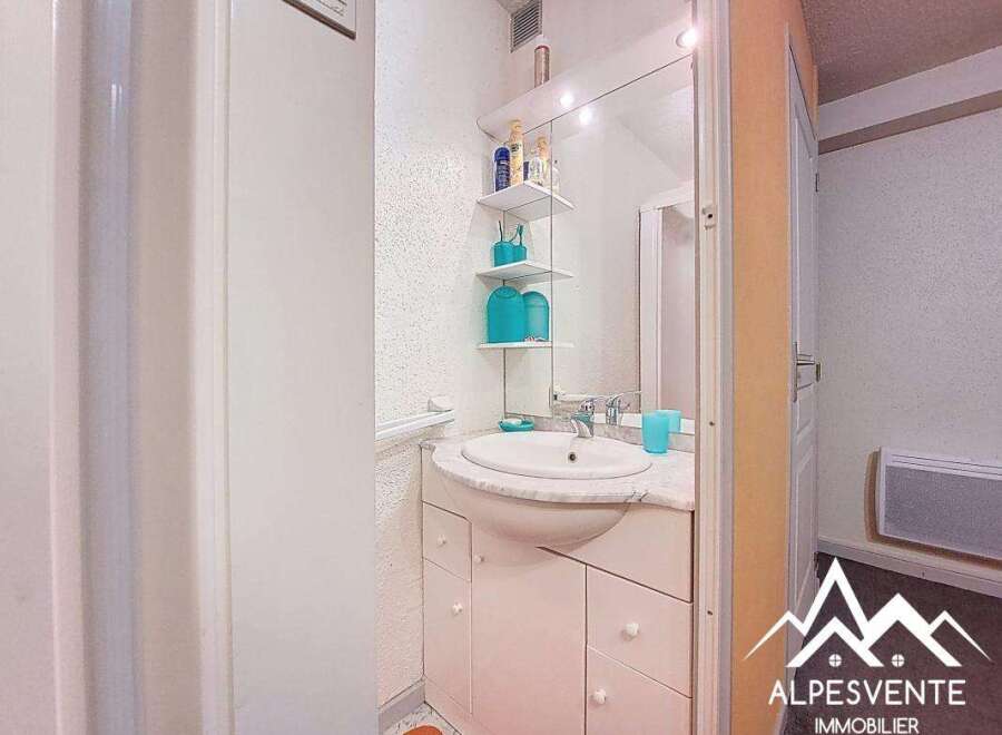 Discover this charming bathroom featuring a stylish sink and ample storage space.