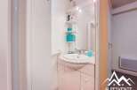 Discover this charming bathroom featuring a stylish sink and ample storage space.