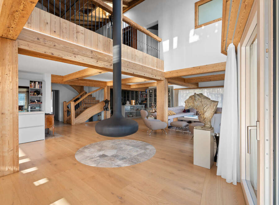 Experience luxury living in this stunning property featuring exposed wooden beams and a modern fireplace.