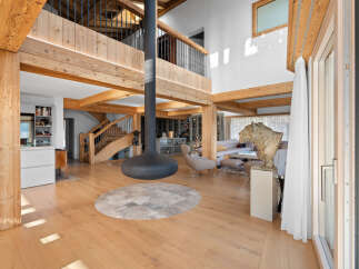 Experience luxury living in this stunning property featuring exposed wooden beams and a modern fireplace.