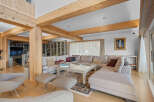 Experience luxury living in this stunning property featuring a spacious living area with exposed wooden beams and a comfortable sectional sofa.