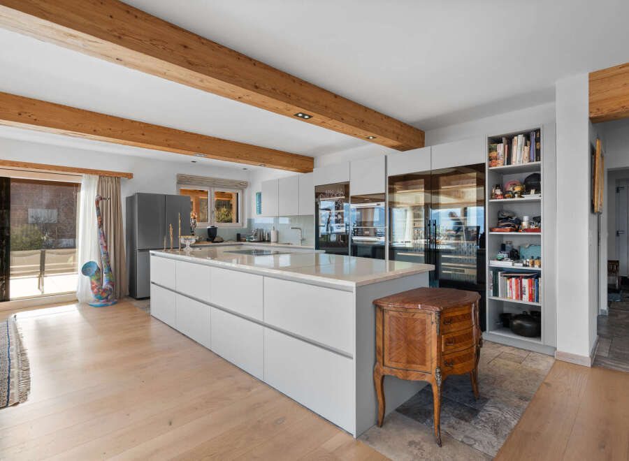 This stunning kitchen boasts a modern design with sleek white cabinetry and a large island, perfect for both cooking and entertaining.