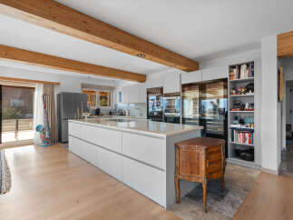 This stunning kitchen boasts a modern design with sleek white cabinetry and a large island, perfect for both cooking and entertaining.