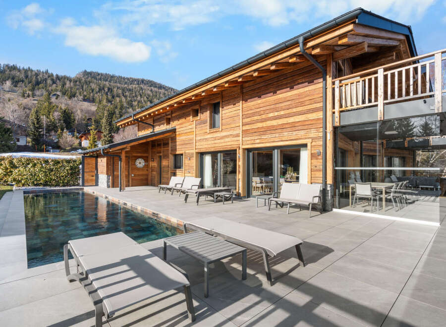 Experience luxury living in this stunning wooden chalet, complete with a private pool and expansive outdoor patio.