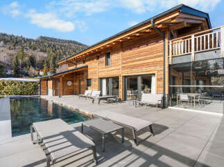 Experience luxury living in this stunning wooden chalet, complete with a private pool and expansive outdoor patio.
