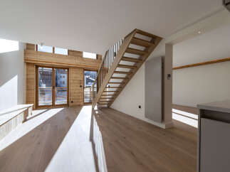 This stunning property boasts a modern interior with a wooden staircase and flooring, creating a warm and inviting atmosphere.
