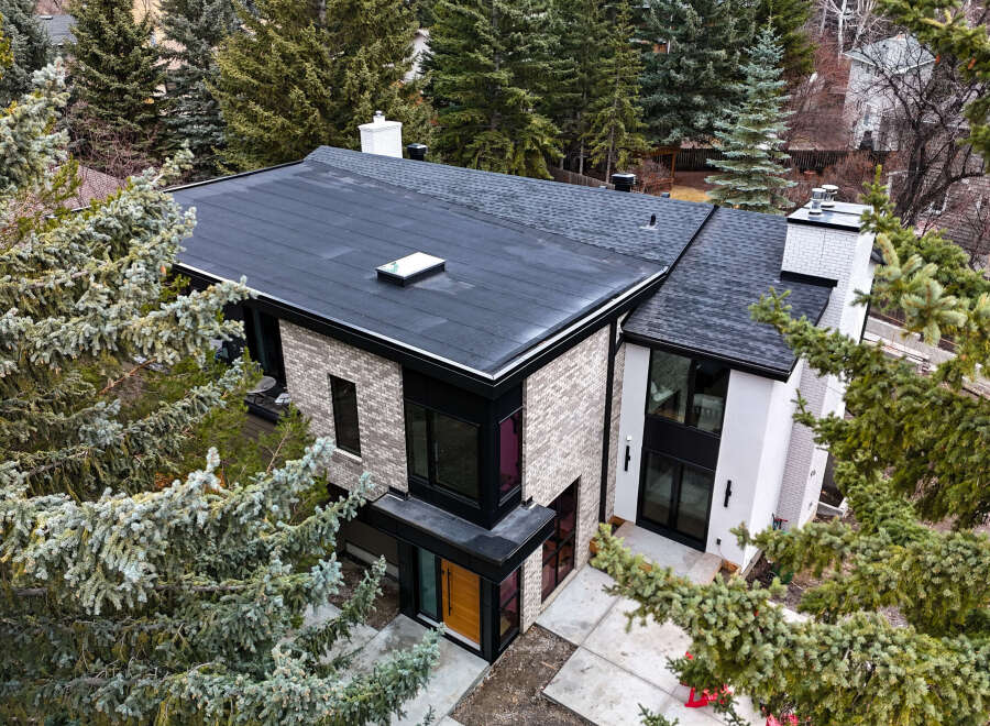 This stunning modern home boasts a sleek, contemporary design with a flat roof and stylish brick facade.