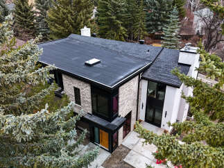 This stunning modern home boasts a sleek, contemporary design with a flat roof and stylish brick facade.