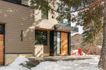This stunning modern home boasts a sleek design with a warm, inviting wooden door and contemporary lines.