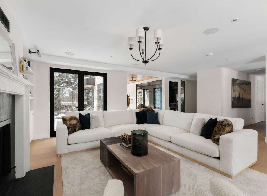 Experience luxury living in this stunning property, featuring a spacious living room with a modern white sectional sofa.