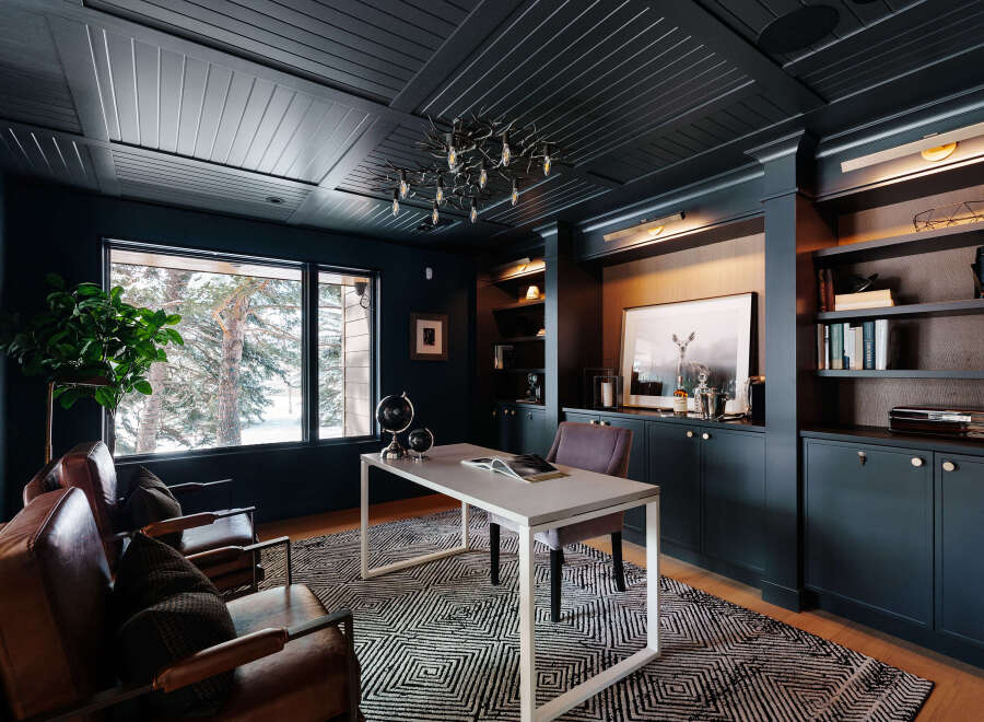 Step into luxury with this stunning home office, featuring a sophisticated dark color palette and custom built-ins.