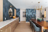 Step into luxury with this stunning dining room, featuring a striking accent wall with a unique forest-themed wallpaper.